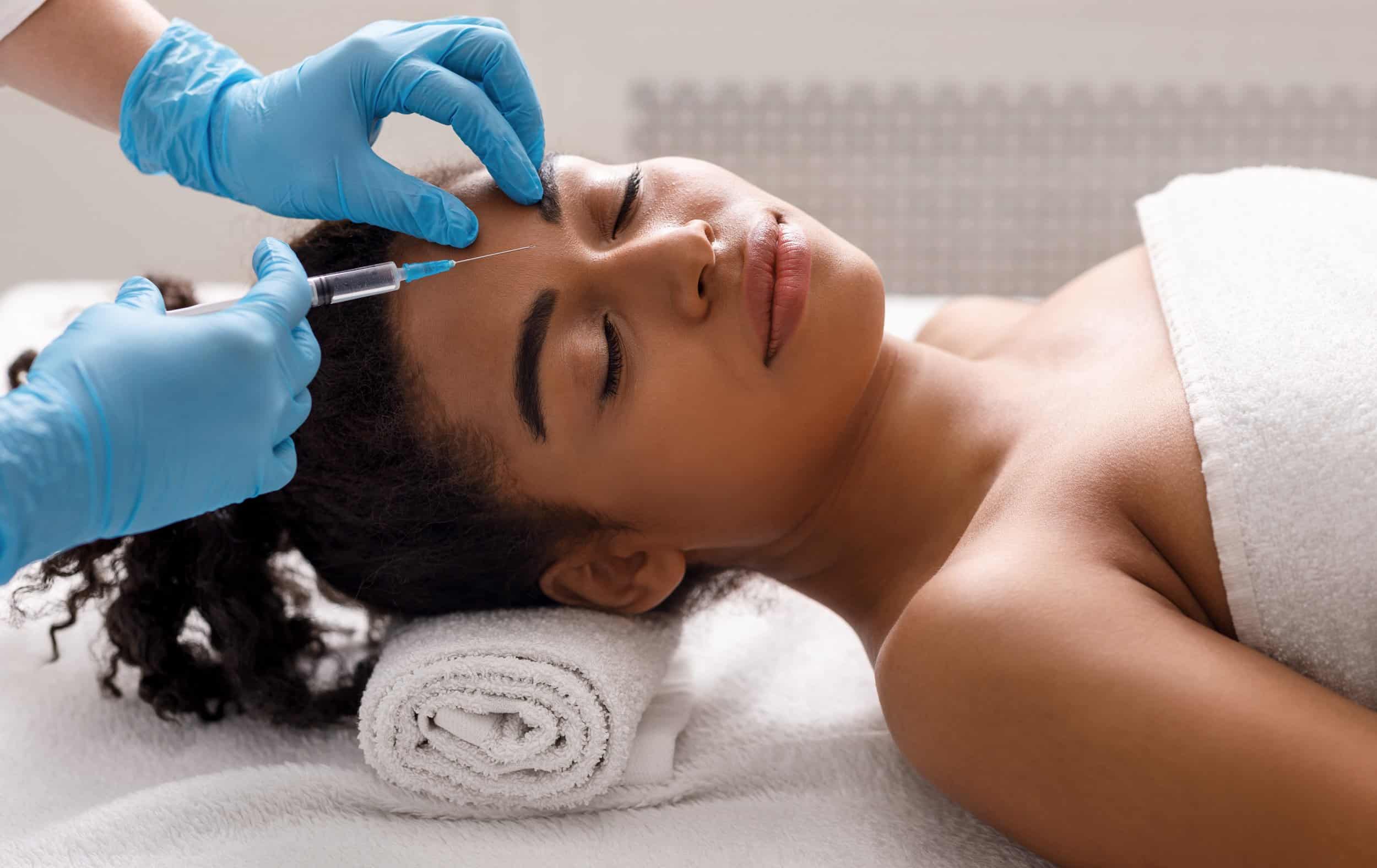 Black woman getting beauty injection at spa